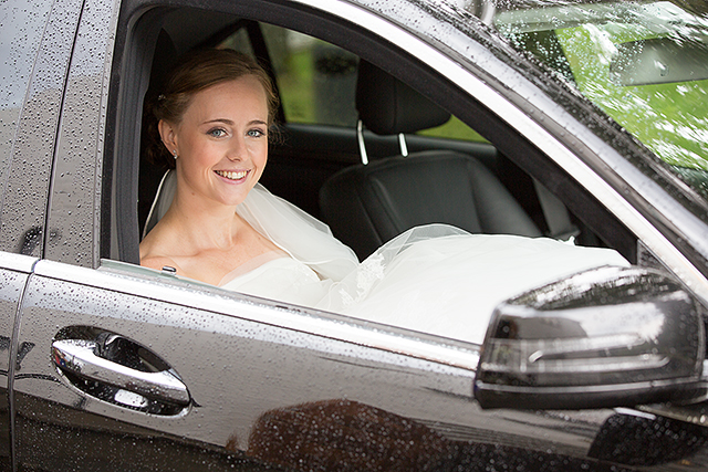 Bruden gjemmer for seg regnet i pappas bil